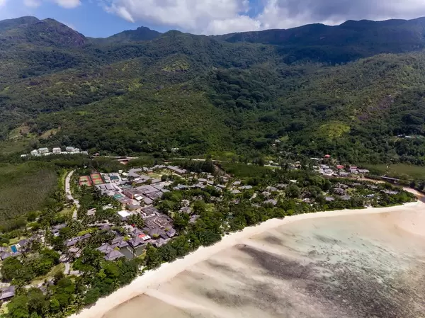 Aerial  Photography of Constance Ephelia Beach Resort in Mahé with view over beach and hillscape of Morne Seychellois National Park