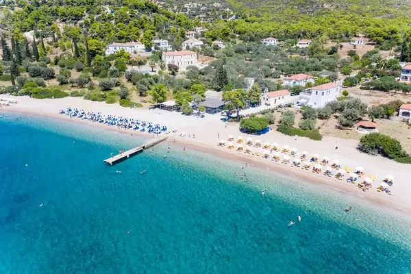 Aerial picture of Parasols and sun chairs separated by color, at Paralia Agii Anargiri Beach on Spetses, Greece