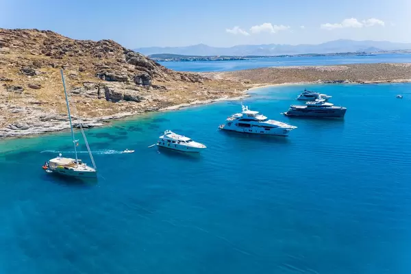 Aerial shot of expensive, luxury boats on the Mediterranean Sea, in a bay between Tourkou Ammos beach and Monastiri Beach, in front of the island Paros, Greece