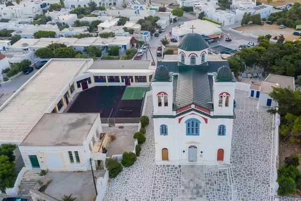 Aerial shot of the colourful main church of the beautiful port city Naoussa on Paros, Greece
