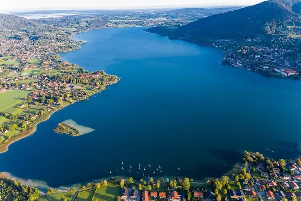 Aerial shot: Tegernsee lake in Bavaria with blue waters, the abbey, the island and towns on the shore