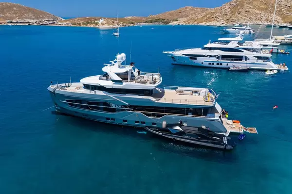 Aerial vie of People on vacation on a multi-storey yacht ship, with a Marvel 41 Passenger Armored rib boat, in a bay near Naoussa, Greece