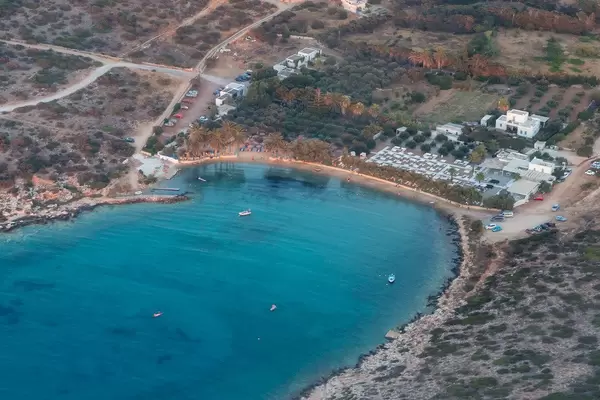 Aerial view of a bay with beach section and blue sea, in front of the Greek island Paros