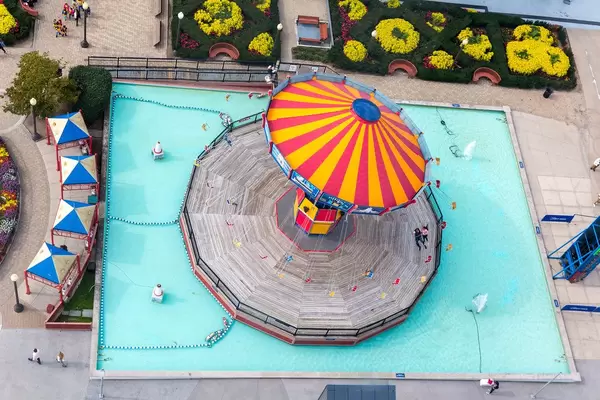 Aerial view of a chairoplane swing carousel with circus colors in a pool at Lake Michigan