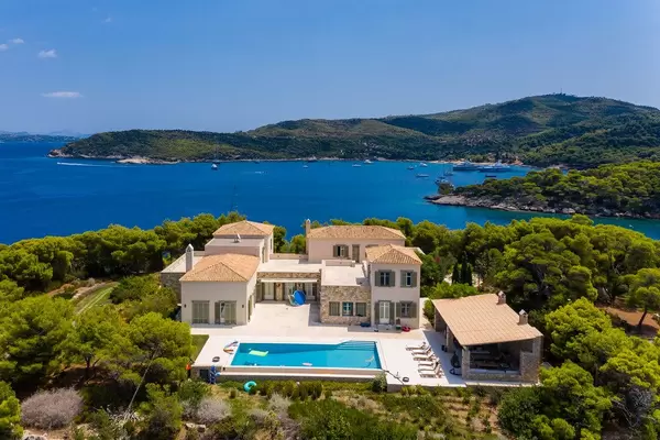 Aerial view of a greek villa with private pool, with view of the blue sea and Paralia Zogeria Beach
