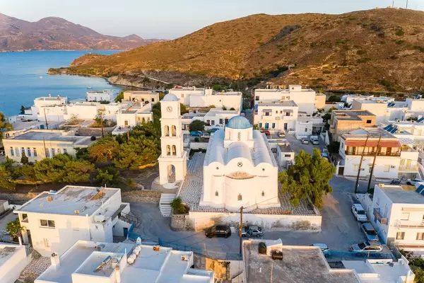 Aerial view of Adamantas, Milos, Greece with white church and bell tower with the typical blue domes