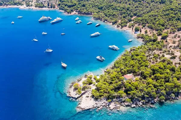 Aerial view of Catamarans and expensive ships In the blue bay at Ekklisia Analipsi of Spetses, next to Agios Georgios Church