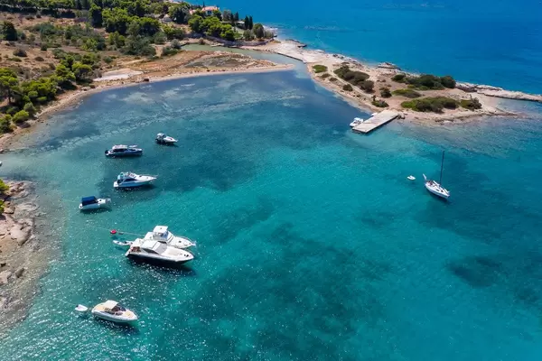 Aerial view of motor boats in a blue bay at Hinitsa Beach in Porto Cheli, Greece