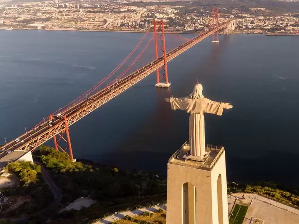 Aerial view of the Cristo Rei statue looking over the Tajo river onto Lissabon with Ponte 25 de Abril bridge