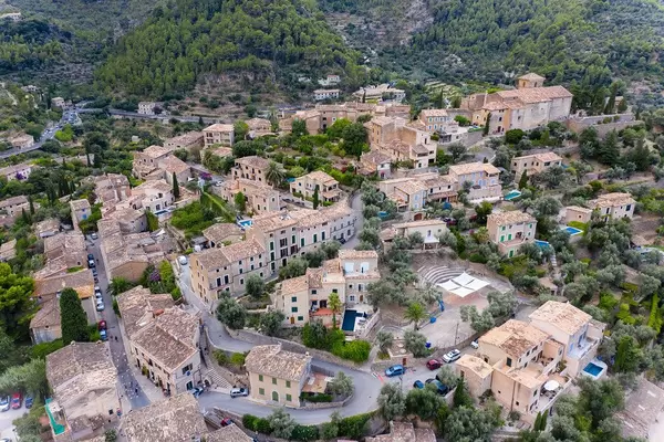 Aerial view of the houses of Deià immersed in the green. Artist village on the west coast of Mallorca