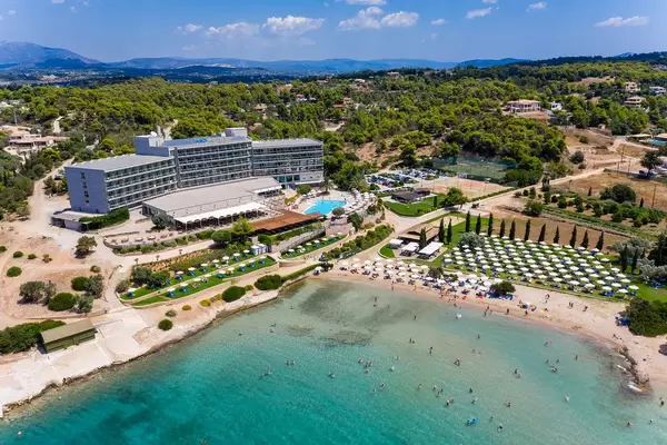 Aerial view of the modern beach hotel Aks Hinitsa Bay and holiday guests in the green sea in front of Chinitsa, Greece