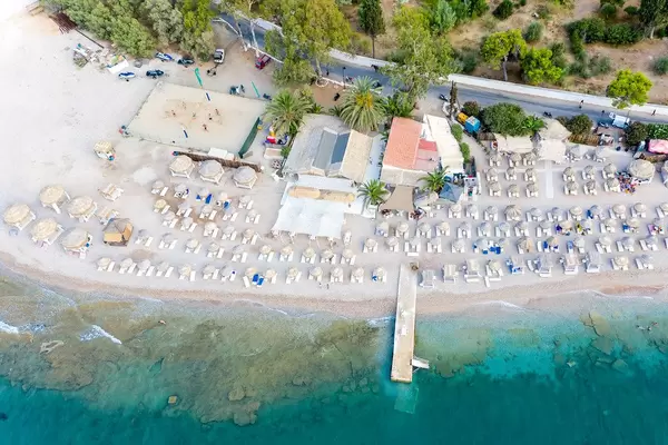 Aerial view of the popular Κaiki Beach with people playing Beachvolleyball, on Spetses, Greece