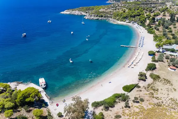 Aerial view of the sea in several blue shades and vacationers on boats in the holiday region Agii Anargiri on Spetses