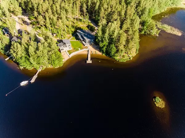 Aerial view shows luxury holiday houses Kiuasniemi Villas, Villa Paapuuri & Villa Jolla with privat wooden jetties at lake Päijänne, vis-à-vis Kalainsaari island