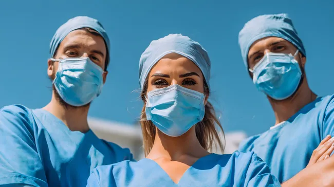 Ärzteteam im Einsatz mit Schutzmasken unter blauem Himmel