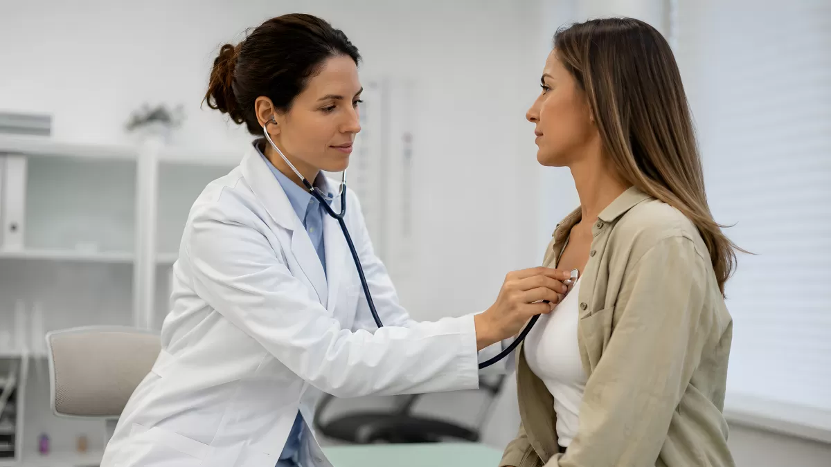 Ärztin untersucht Patientin mit Stethoskop in Praxis