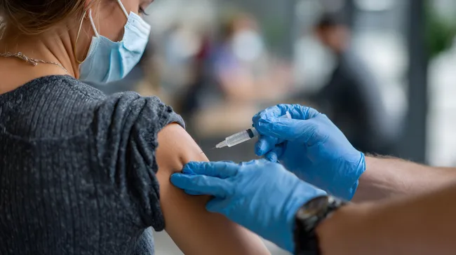 Ärztin verabreicht COVID-19-Impfstoff in Gesundheitseinrichtung