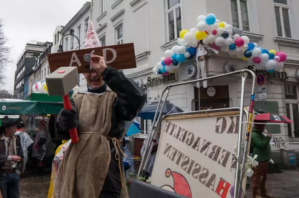 Personen mit Holzbrett vor Gesicht