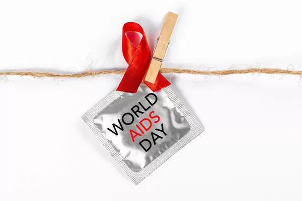 Aids awareness sign red ribbon and a condom