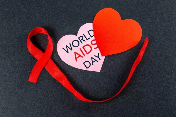 Aids day. Two hearts with red ribbon on a black background