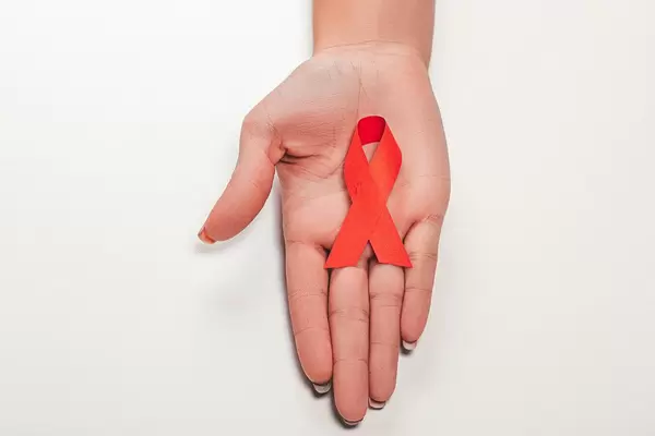 Aids red ribbon on woman's hand support for World aids day and national HIV/AIDS and aging awareness month concept
