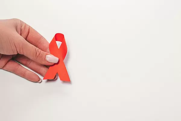 AIDS ribbon in hands on white background (Flip 2019)
