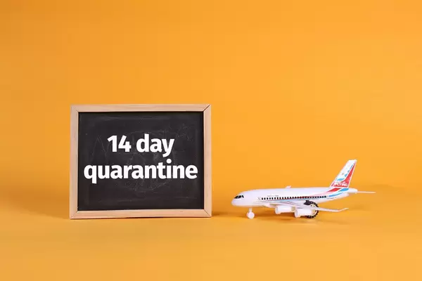 Airplane and blackboard with 14 day quarantine text
