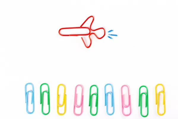 Airplane made of paper clips, business background