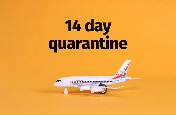 Airplane with 14 day quarantine text on orange background