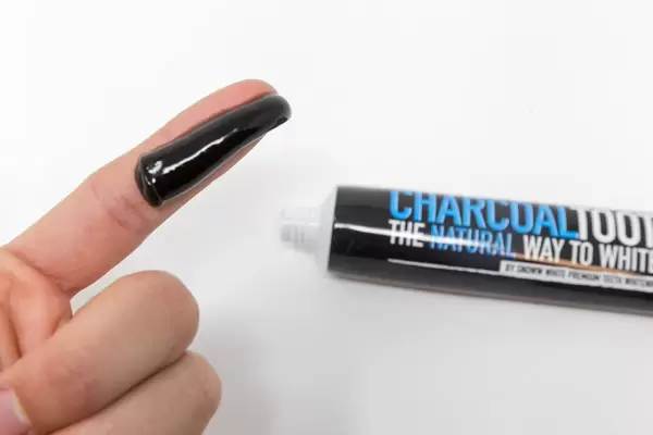 Aktivkohle Kokosnuss Zahnpasta auf einem Finger