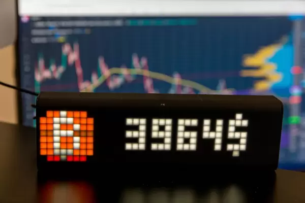Aktueller Bitcoin Kurs, angezeigt mit der Lametric Uhr, vor einem verschwommenen PC-Bildschirm