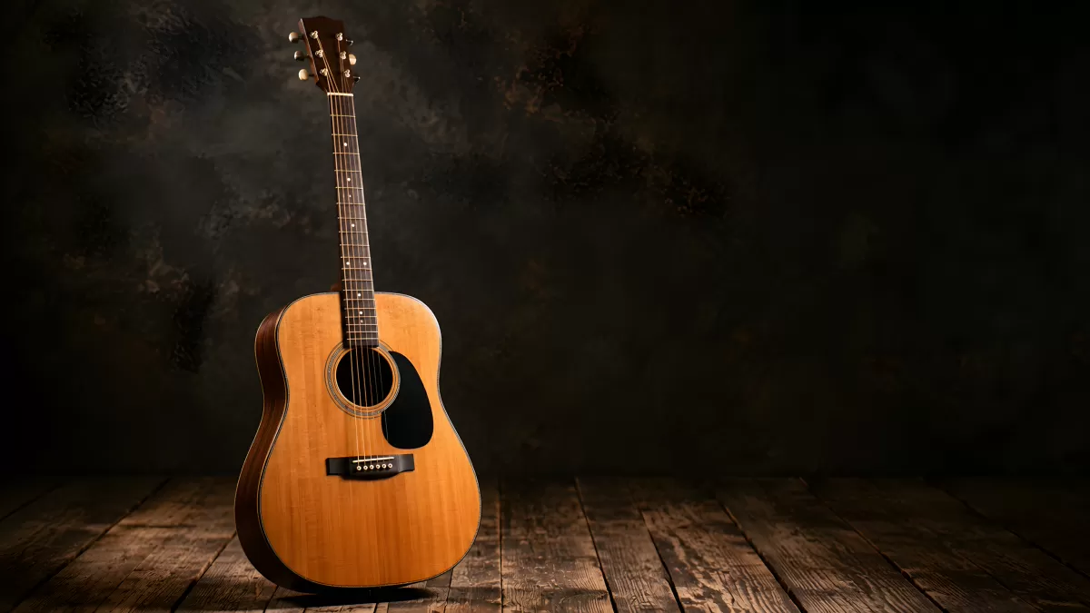 Akustikgitarre auf altem Holzboden im Scheinwerferlicht