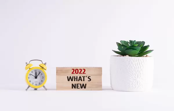 Alarm clock and flower with 2022 What's New text