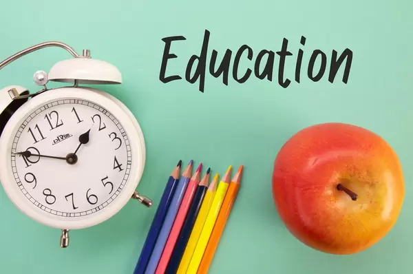 Alarm clock, colored pencils and apple with Education text
