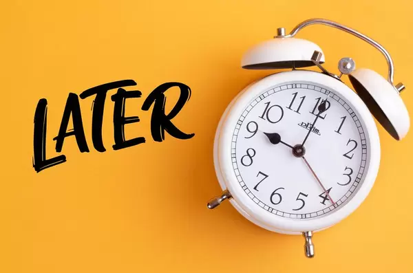 Alarm clock with handwritten text Later on yellow background