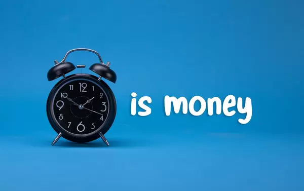 Alarm clock with Time is money text on blue background