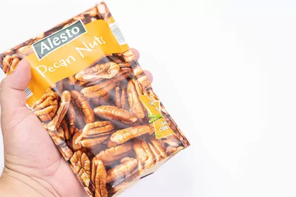 Alesto Peckan nuts package in the hand with copy space