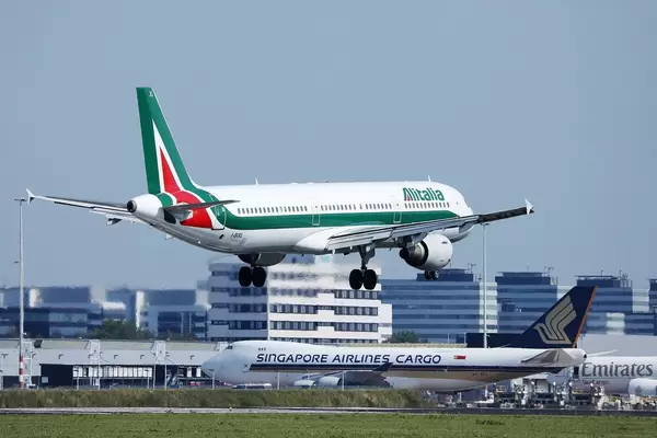 Alitalia Flugzeug landet in Amsterdam und Singapore Airlines rollt zum Terminal