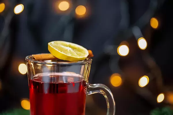 Alkoholisches Weihnachtsgetränk mit Zitrusfrucht und Gewürzstange