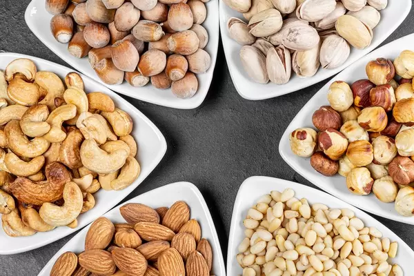 Almonds, hazelnuts, pine nuts, pistachios, cashews and filbert in triangular bowls
