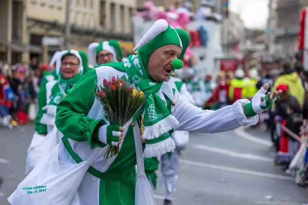 Als Narr verkleideter Mann in grün-weiß mit Blumen - Kölner Karneval 2018