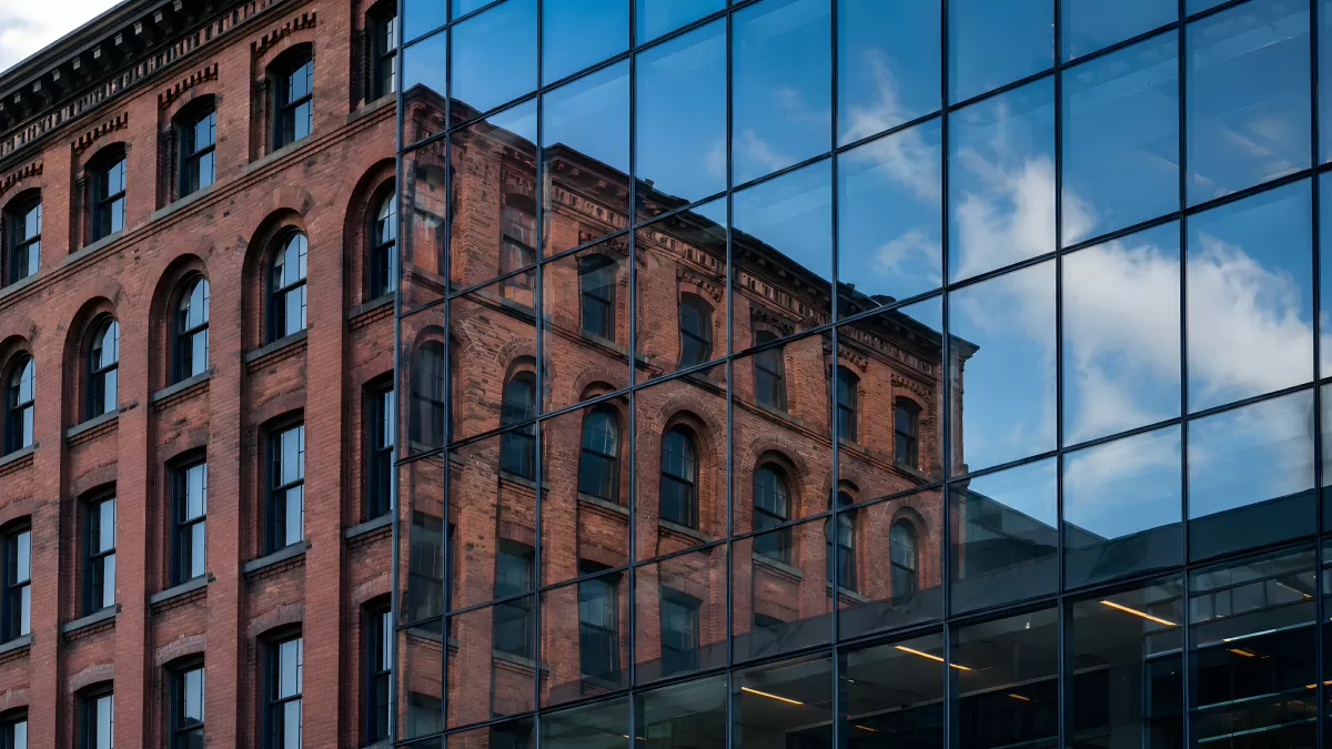 Altbau spiegelt sich in moderner Glasfassade