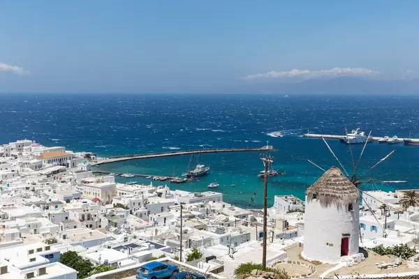 Alte Windmühle auf dem Hügel mit Blick auf Chora und den Hafen von Mykonos, Griechenland