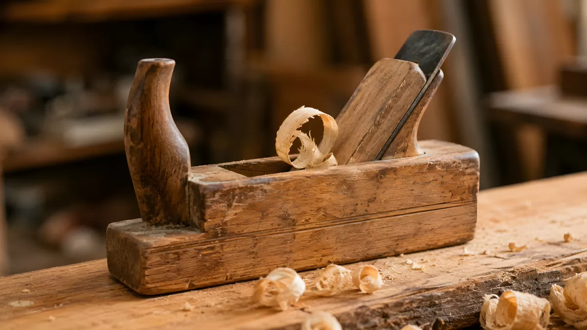 Alter Holzhobel mit Spänen auf Werkbank in Tischlerei
