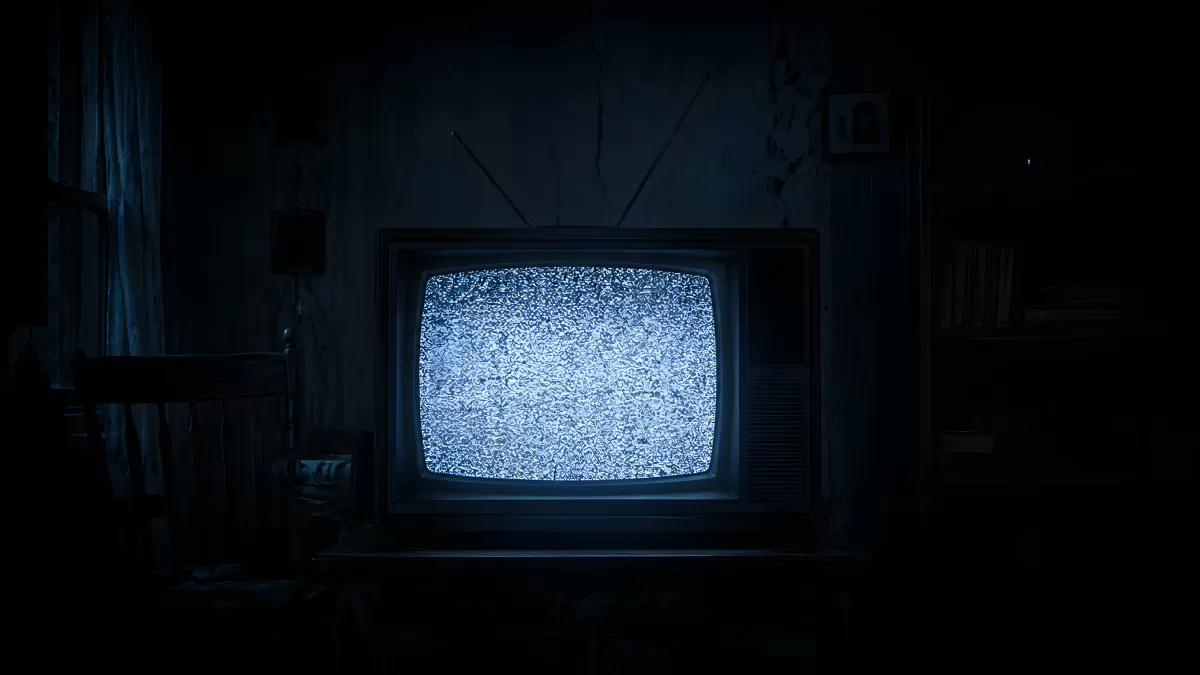 Alter Röhrenfernseher mit Rauschen im dunklen Zimmer