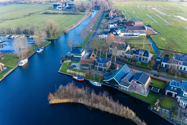 Am Wasser erbaute Häuser mit Booten in Akmarijp, Niederlande
