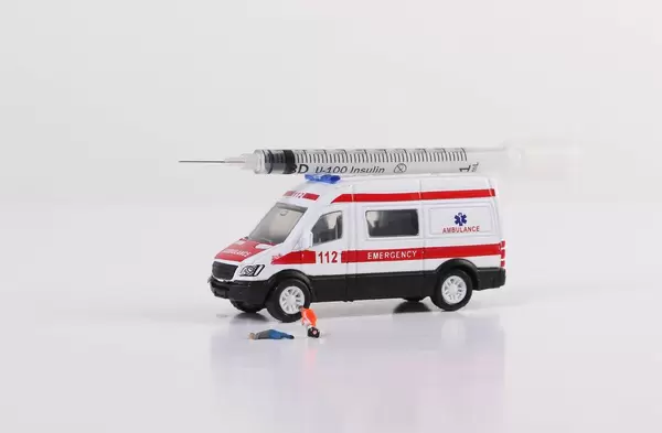 Ambulance car with syringe on white background