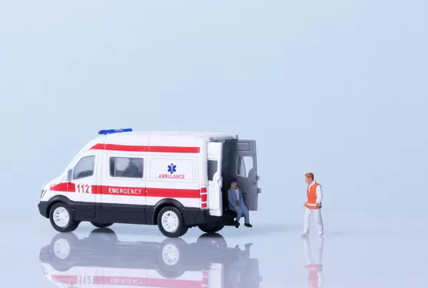 Ambulance, medical worker and patient on light blue background