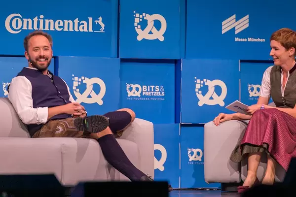 American entrepreneur Drew Houston smiles while being interviewed by Britta Weddeling in perfect Oktoberfest outfit at the Bits & Pretzels conference