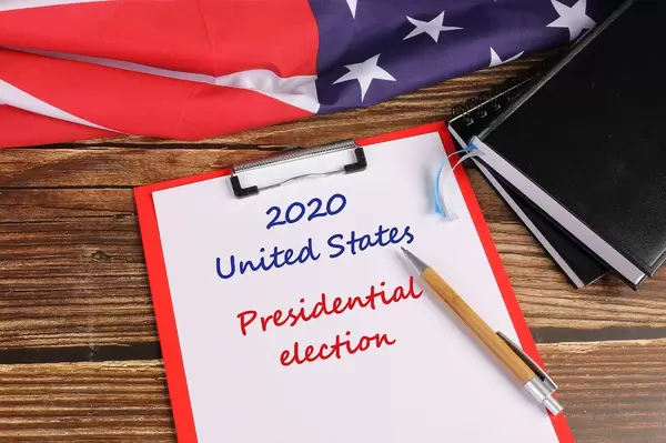 American flag on wooden table with 2020 United States Presidential election text